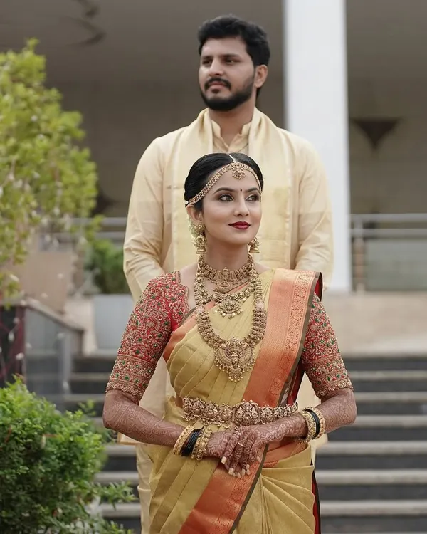 My stunning bride Taanya, looking absolutely regal in a golden Kanjivaram saree paired with a custom red embroidered blouse for her muhurtham.