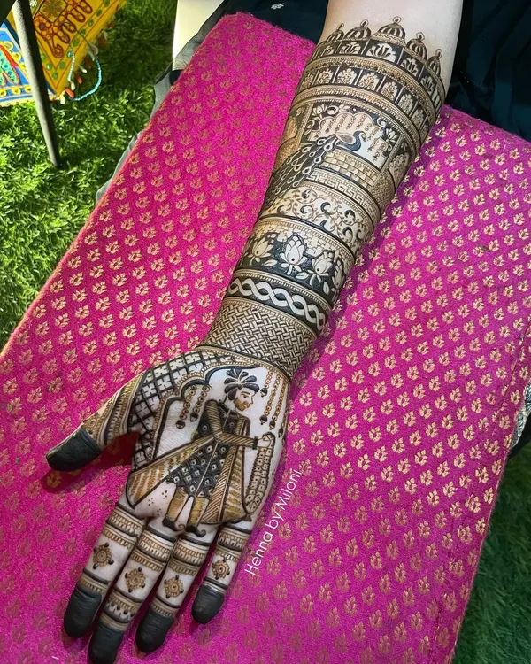 A full arm bridal mehendi featuring a detailed portrait of a groom. The design incorporates traditional Rajasthani architecture and peacock motifs.