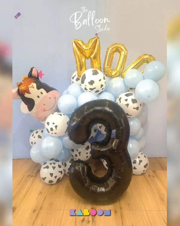 Moo-ve over boring decorations! This adorable farm-themed balloon bouquet features a cow balloon, cow-print accents, and a large number three for a fun-filled third birthday.