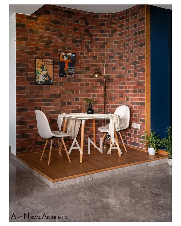 This breakfast deck in Apartment 704 was created by repurposing underutilized space. A curved raw brick wall provides a textured backdrop, creating a cozy and distinct zone for casual dining.