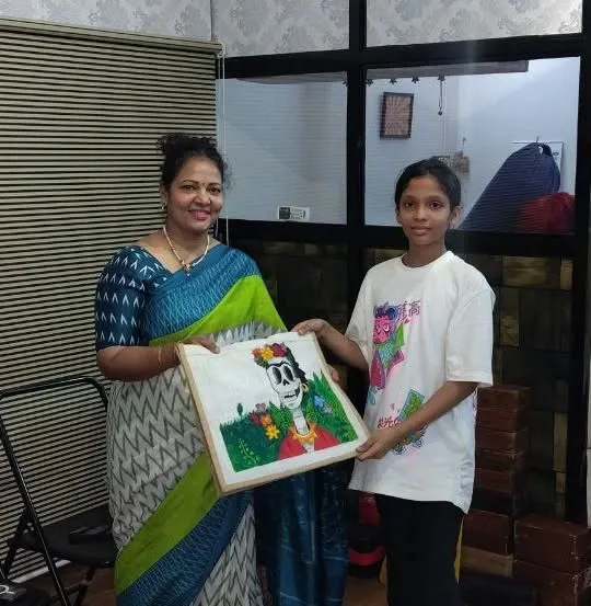 Anaya, an 8th standard student, with her finished tote bag art. She used acrylics on the jute bag to create a unique design inspired by Frida Kahlo.