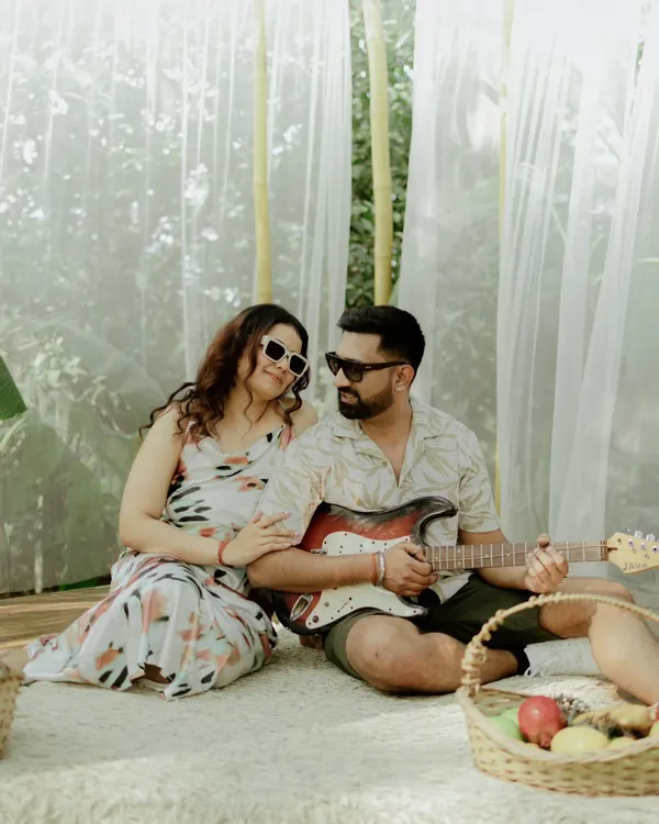A relaxed picnic-themed shot where the groom plays the guitar for his bride-to-be. This setup is perfect for a casual and musical couple.