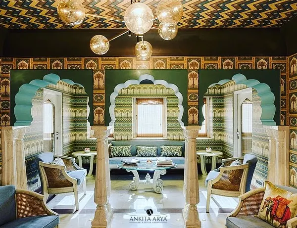 For the Surya Haveli in Jaipur, I designed a series of wallpapers that celebrate the city's rich heritage. This sitting area features multiple patterns, from geometric ceilings to arched murals, creating a truly royal experience.