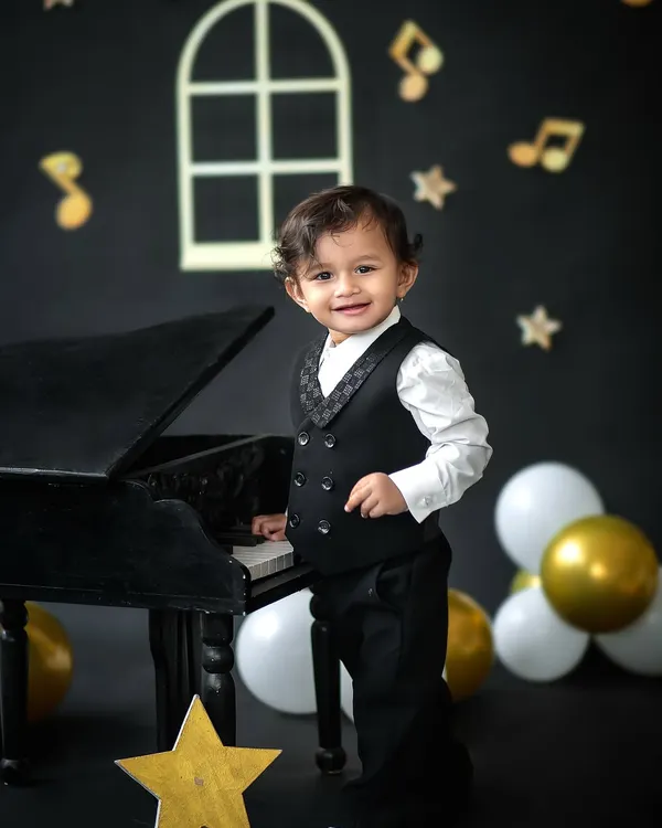 Our little maestro, looking dapper and ready for his piano debut. This music-themed first birthday shoot combines classic style with playful fun.