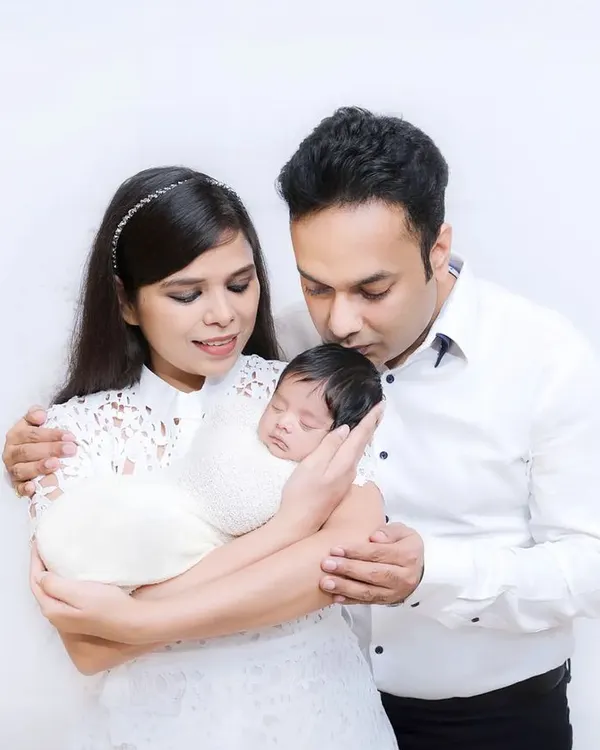 A tender moment with new parents cradling their sleeping newborn. The all-white theme gives this first family portrait a pure and serene quality.