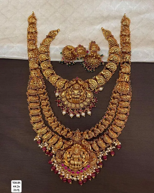 This is a magnificent bridal combo set made from 92.5 silver with gold plating. It includes a choker and a long haram, both featuring intricate temple designs with goddess motifs for a complete, divine look.
