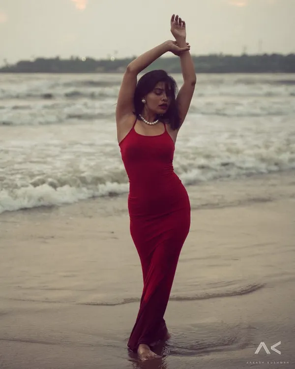 A full-length portrait of a model in a red dress against the waves. This shot is about capturing graceful movement and the powerful contrast between the subject and the sea.