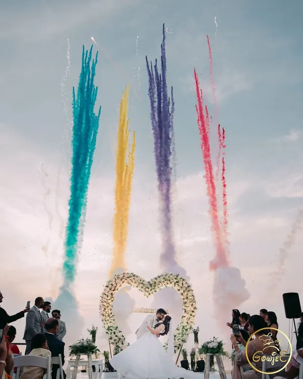 A spectacular destination wedding moment, with colorful fireworks lighting up the sky as the couple shares a kiss.