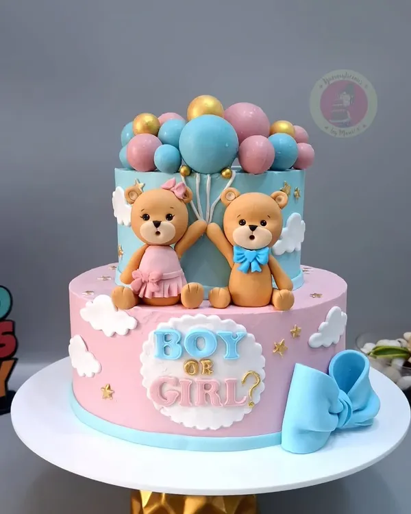 A beautiful two-tier "Boy or Girl?" gender reveal cake, featuring cute teddy bears and a cascade of pink and blue balloons.