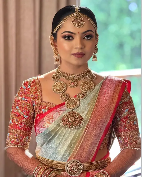 Our beautiful bride Anusha, looking absolutely regal on her wedding day. The heavily embroidered blouse was custom-designed to match her stunning saree and traditional jewellery.