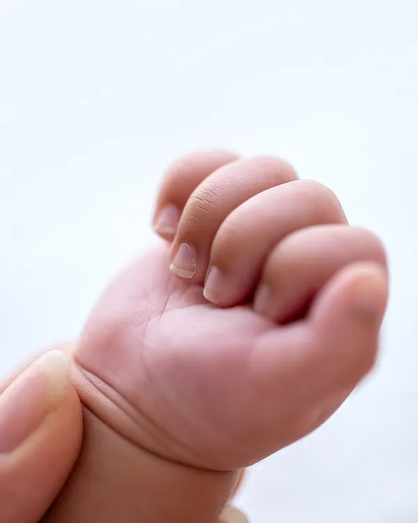 A tiny hand, perfectly formed, grasping a parent's finger. These are the details you'll want to hold onto forever.