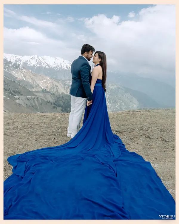 A breathtaking shot in Gulmarg, Kashmir, where the bride's flowing blue gown contrasts stunningly with the snow-capped mountains. This is the kind of epic, cinematic portrait that a destination like Kashmir makes possible.