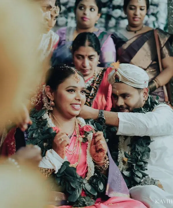 A candid moment from a South Indian wedding ceremony, capturing the bride's happy expression as the groom performs a ritual. These are the unscripted memories I love to freeze.