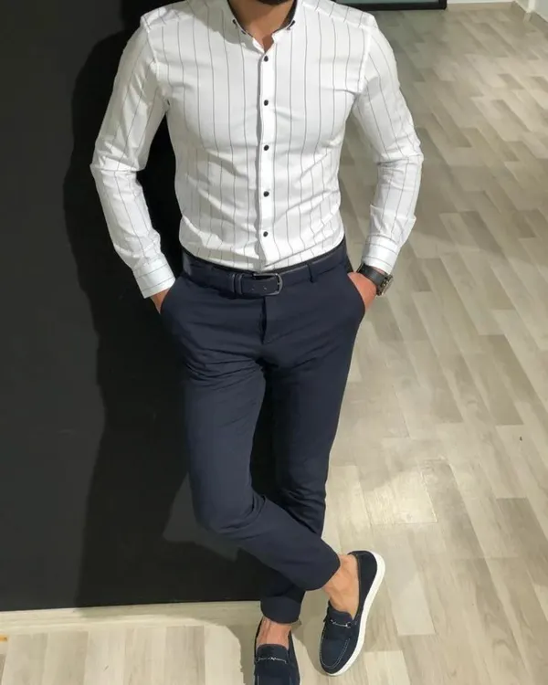 A demonstration of a perfect fit with this custom-tailored white pinstripe shirt and navy blue formal trousers. Notice how the shirt contours to the body without being tight, a result of precise at-home measurements. This is the sharpness I bring to your office and formal wear.