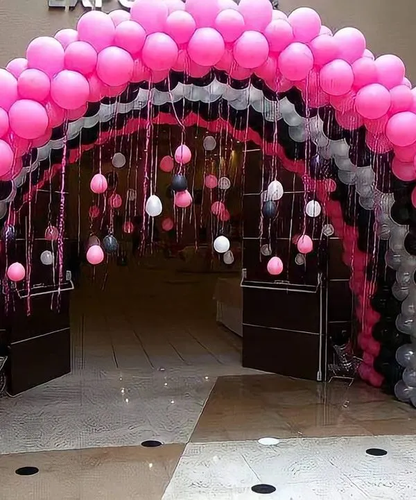 A grand balloon arch I built to create an impressive entrance tunnel for an event. The layered design uses pink, black, and white balloons to guide guests into the party space with style.