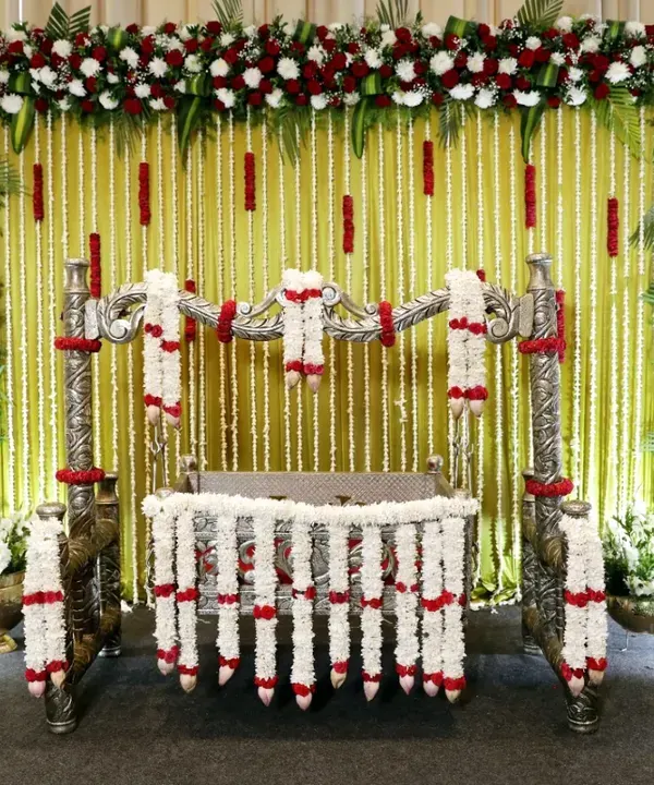 A classic and elegant naming ceremony setup. I used strings of fresh tuberose (malli poo) and a floral border of red and white roses to create a beautiful backdrop for the decorated thottilu (cradle).