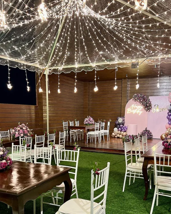This beautiful birthday celebration under a canopy of fairy lights is what we live for. We transformed this rooftop space into a magical, starlit garden with custom seating, lush florals, and a personalized backdrop, creating an unforgettable evening.