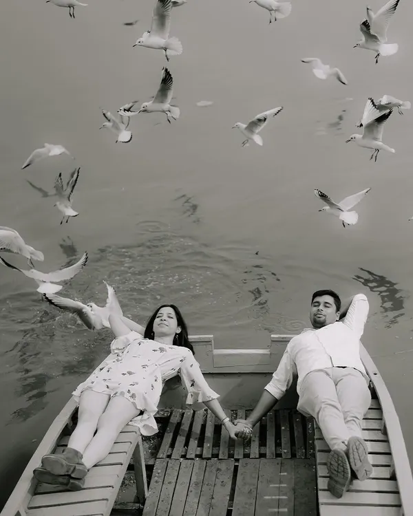 This is what it's all about for me. A quiet, shared moment on a boat, surrounded by the gentle flutter of birds. This black and white intimate portrait captures the pure, unspoken romance of a pre-wedding shoot.