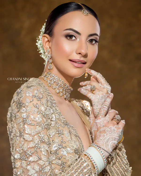 This is the modern minimalistic bride. The look is created with airbrush makeup for a flawless, lightweight finish that lasts all day. Paired with delicate white henna, it's a perfect blend of contemporary style and tradition.