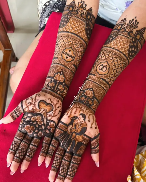 This engagement mehandi tells a love story with a detailed couple portrait on one palm and a heart motif on the other. The design extends up to the elbows, featuring intricate patterns and the groom's name, 'Onkar', hidden within a heart.