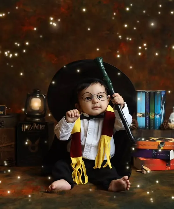 Your little one is ready to cast a spell in this magical Harry Potter themed toddler shoot. Seated among glowing candles and classic books, this setup captures the wonder of the wizarding world.