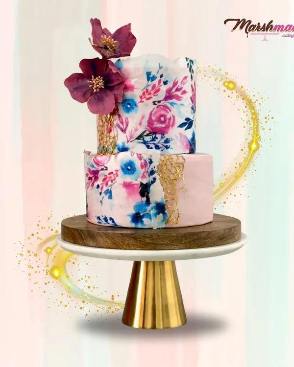 This two-tiered floral boho dream cake was a labour of love, taking two full days to create. The combination of royal blue and burgundy, along with delicate handmade sugar flowers, makes for a truly unique centerpiece for any grand celebration.