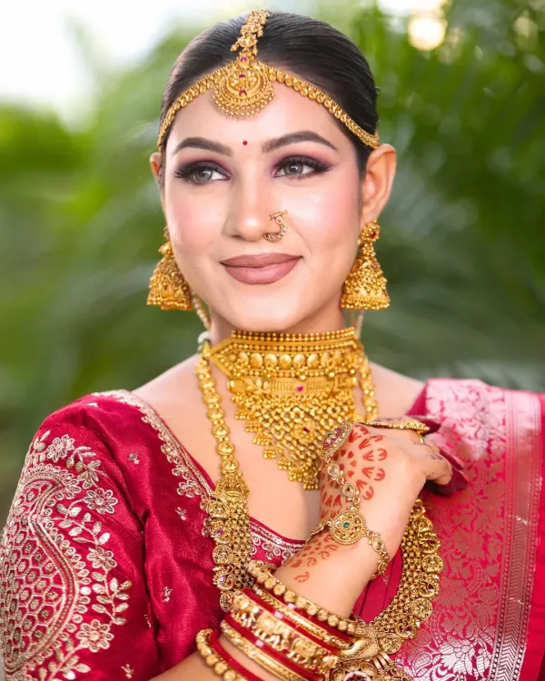 A beautiful candid shot of our South Indian bride. Her makeup features a soft smokey eye and a neutral lip, perfectly balancing the heavy gold jewelry and letting her natural beauty shine.