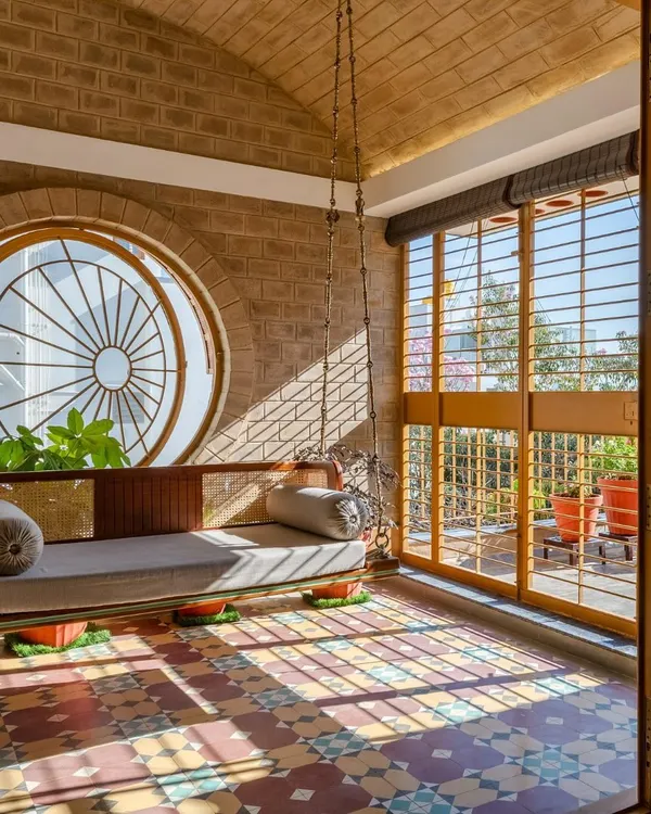 This handcrafted teak and rattan swing is more than a piece of furniture; it's a peaceful corner for reflection. Set against a vaulted brick ceiling and patterned cement tiles, it captures our love for natural materials, sunlit spaces, and creating furniture with a soul.