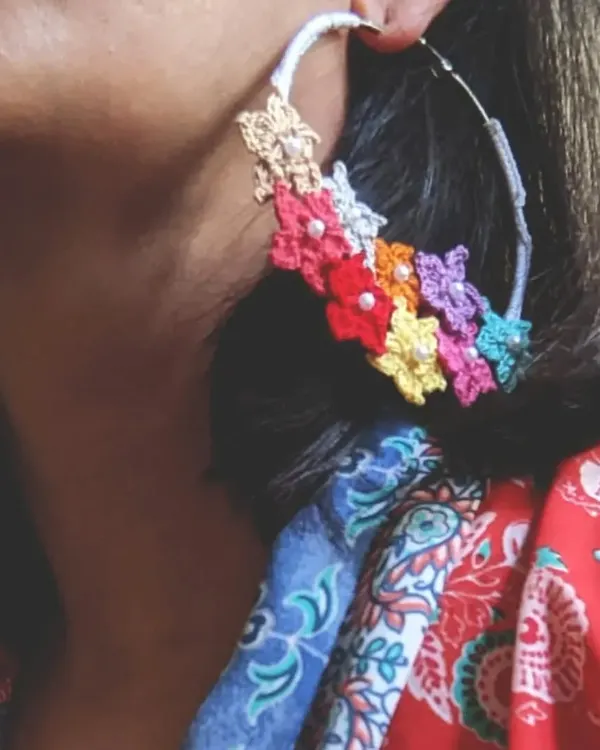 Here are our signature floral crochet hoop earrings being worn. You can see how the vibrant, multi-colored flowers create a beautiful statement piece that is still light and easy to wear.