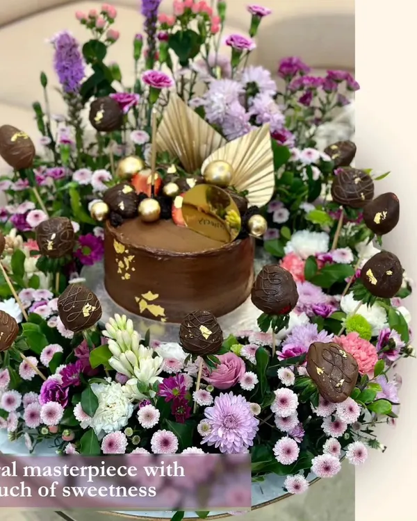 This floral masterpiece is one of my grandest creations. A rich chocolate cake sits at the center of an extravagant arrangement of fresh flowers and chocolate-covered strawberry pops, making for an unforgettable centerpiece.
