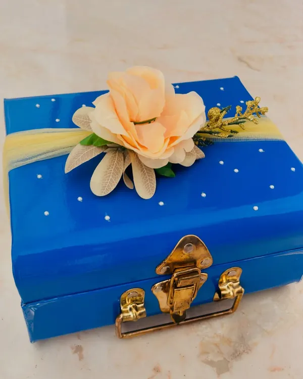 A special delivery for the bride-to-be. This beautiful blue trunk is decorated with a delicate flower and ready to be filled with goodies for her journey to the aisle.