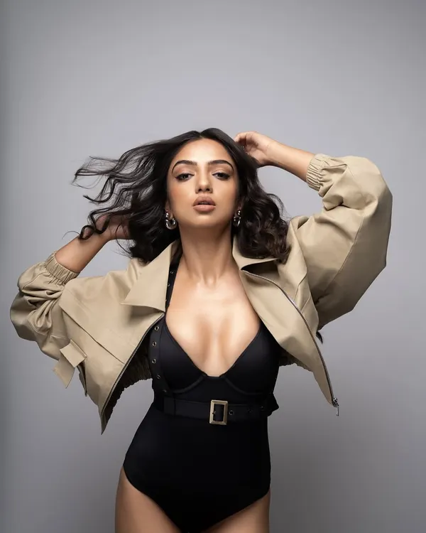 Birthday energy for Ahsaas Channa. This powerful look for her birthday photoshoot features a black belted bodysuit paired with a cropped khaki jacket and platform heels.
