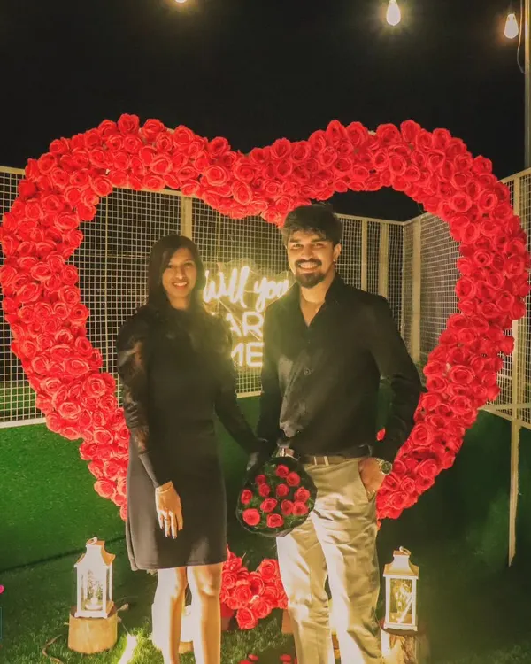The perfect photo opportunity after a successful proposal. The happy couple stands inside the large, rose-covered heart, creating a beautiful memory of their special night.