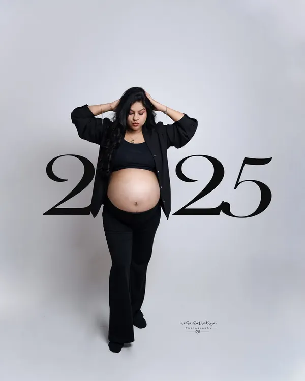 The "Boss Mom" look. This confident pose in a modern black pantsuit with the baby bump proudly displayed is for mothers who are leaders in every aspect of their lives.