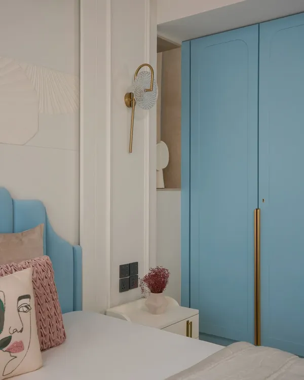 A serene sanctuary for a young couple, this master bedroom features a custom powder blue headboard and intricate 3D MDF panels. The design blends classic New English charm with modern luxury.