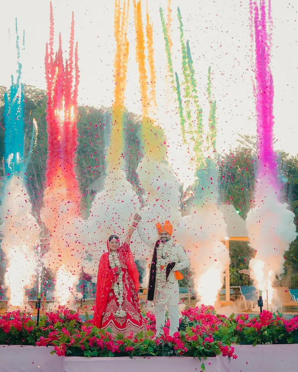 This is what pure celebration looks like. We love creating these spectacular, high-energy moments during the varmala ceremony, using elements like colored smoke to make your wedding photos unforgettable.