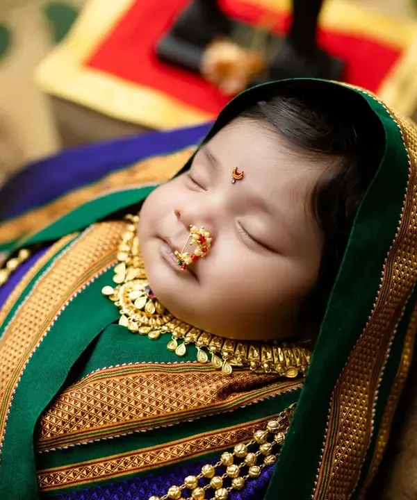 A beautiful 'Marathmoli' newborn shoot, celebrating Maharashtrian tradition. The rich texture of the Paithani saree wrap and the traditional jewelry make for a stunning cultural portrait.