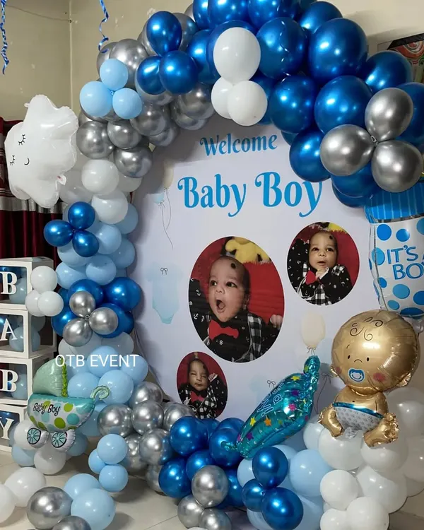 For this "Welcome Baby Boy" celebration, I designed a custom backdrop featuring the baby's own photos. The blue and silver balloon arch and themed foil balloons make it a truly personal and heartwarming setup.