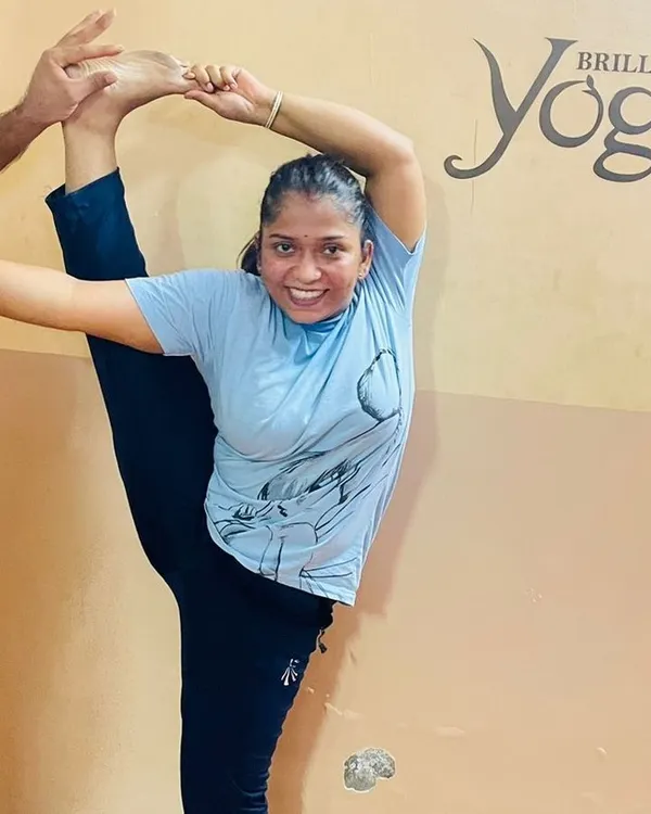 With dedicated practice and expert guidance, students can achieve remarkable flexibility and strength. Here, a student works on the standing splits, a testament to her hard work.