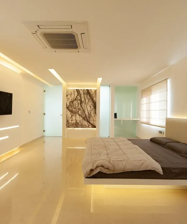 a wide view of a bedroom centered around a custom floating bed… the design incorporates integrated wall lighting and a cantilevered media unit, all designed to make the space feel expansive and uncluttered.