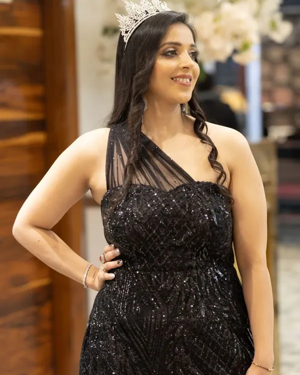 A perfect look for a glamorous evening event. The makeup features a soft smokey eye, luminous skin, and a neutral lip, allowing her sequined black dress and tiara to take center stage.