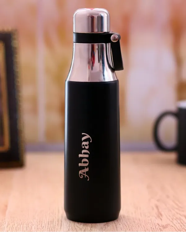 A sleek and modern personalized bottle in black and silver. I can engrave any name, like "Abhay" shown here, making it a stylish and personal accessory for the gym or office.