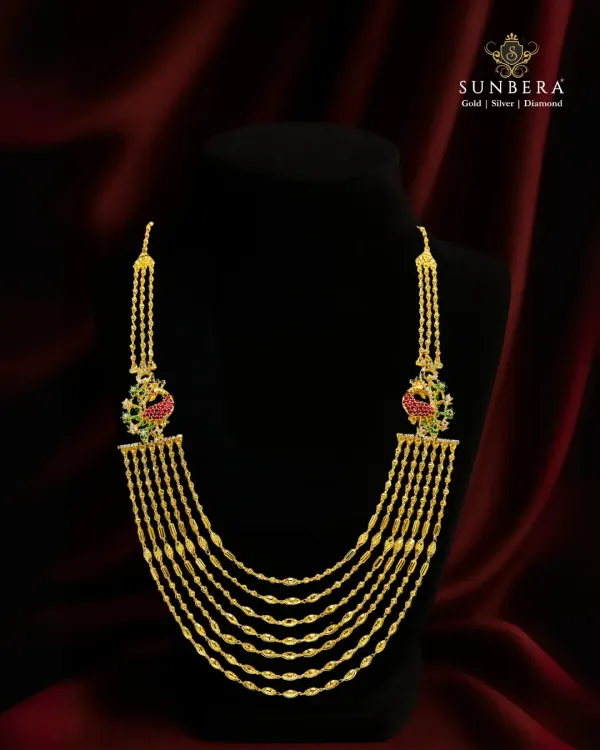 This multi-layered peacock mala in 22K gold is a perfect example of royal design meeting timeless craft. Each detail, from the cascading gold chains to the enameled peacocks, is handcrafted to create a piece of heritage jewellery.