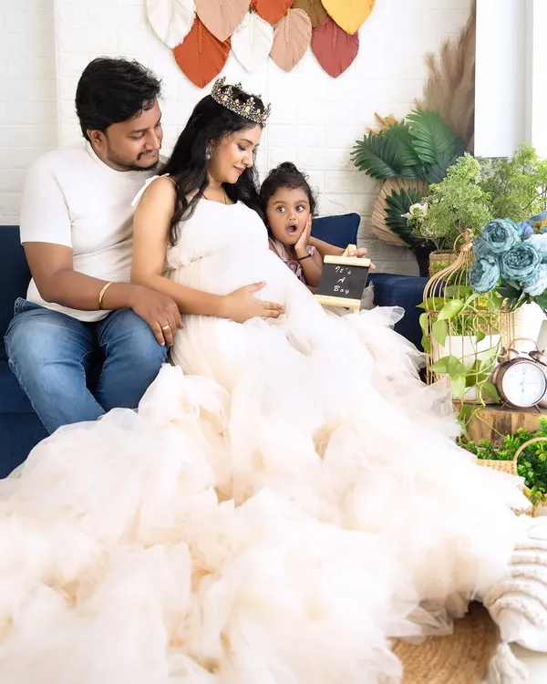 A candid and adorable family moment on the couch, with the older sister making a surprised face. It's these real moments that make the best memories.