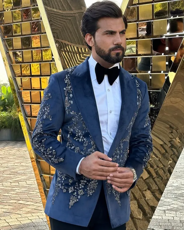 A masterpiece for your most important events. This hand-embroidered Nacre Tuxedo in a deep navy blue is crafted to ensure you are the center of attention. The intricate floral embroidery on the lapels and shoulders adds a layer of sophisticated detail.