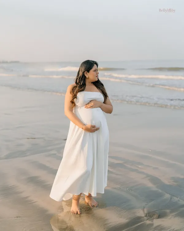 Standing by the ocean, carrying a world of dreams within. This solo beach portrait is all about capturing the serene and powerful connection between mother and nature.