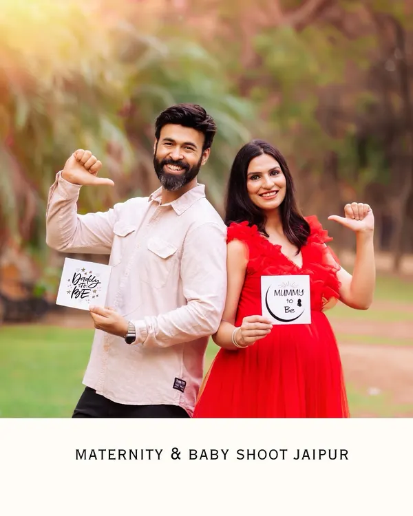 A fun and playful couple posing back-to-back with "Daddy to be" and "Mummy to be" signs. This is a perfect shot for a joyful pregnancy announcement.