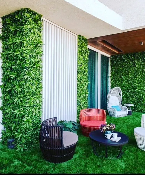 A complete balcony transformation featuring lush artificial grass flooring and vertical green walls. I can turn any outdoor area into a comfortable living space with custom seating arrangements.