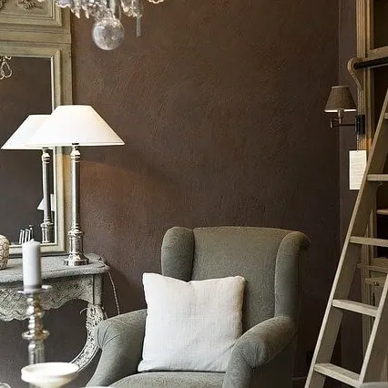 A subtle, brushed texture on a dark brown wall adds warmth and sophistication to this classic living room. This finish provides an elegant alternative to a flat paint surface, enhancing the room's cozy feel.