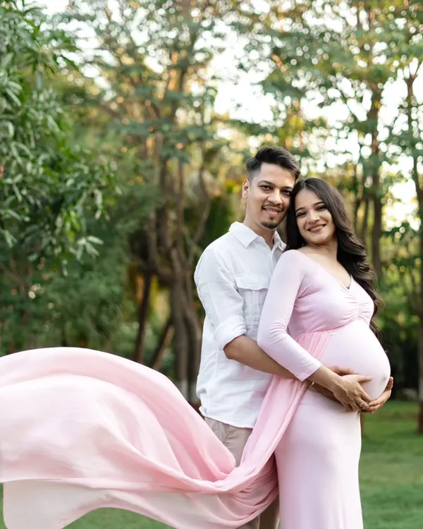 A perfect day for an outdoor shoot! This couple looks so happy together, surrounded by lush greenery. The way the pink fabric of her gown flows in the breeze adds a beautiful, dynamic element to the photo.